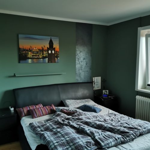 Nachherbild eines dunkelgrün gestrichenes Schlafzimmer mit Blick auf Bett